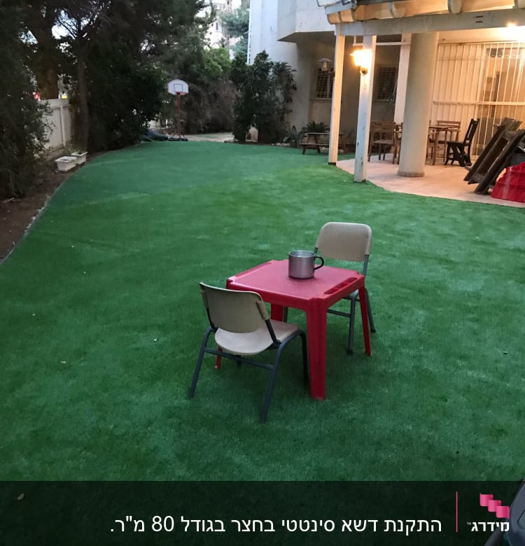 דשא סינתטי עם שולחן וכיסאות בגינה
